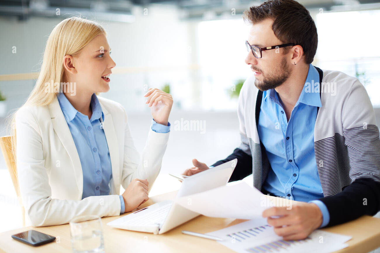 two-business-people-discussing-plans-or-project-at-meeting-DF0J4N